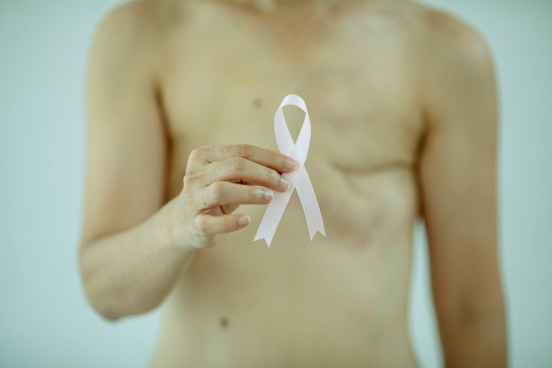 woman showing ribbon symbolizing breast cancer